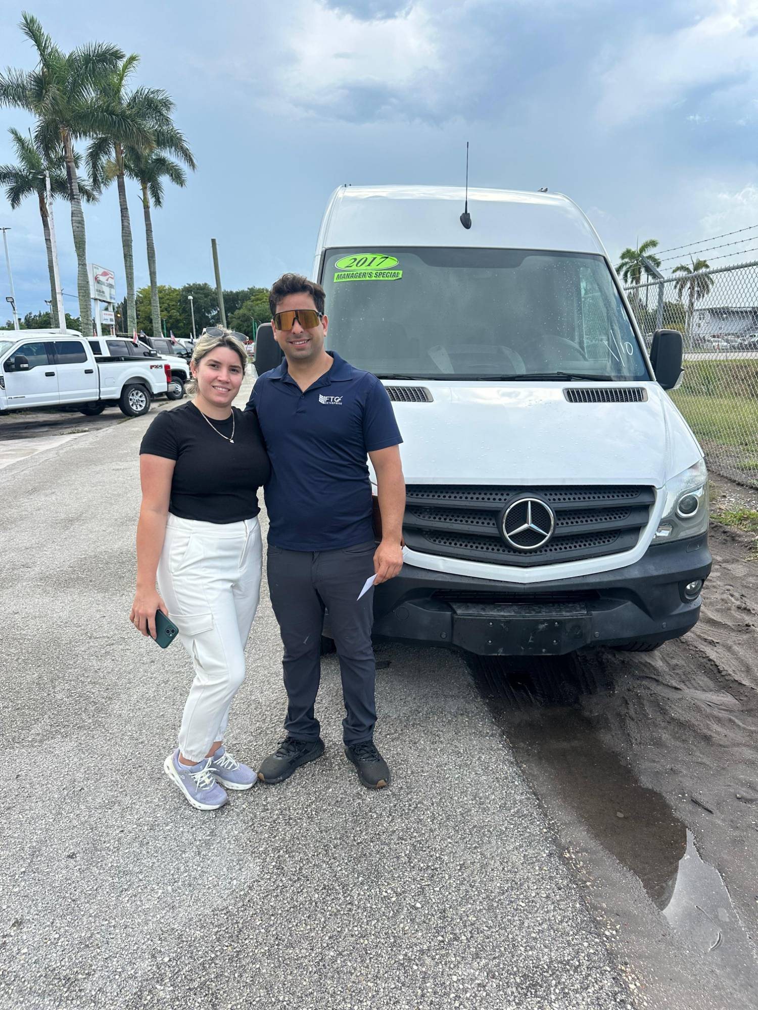 A couple with their white Mercedes Sprinter van on the National Car Store lot