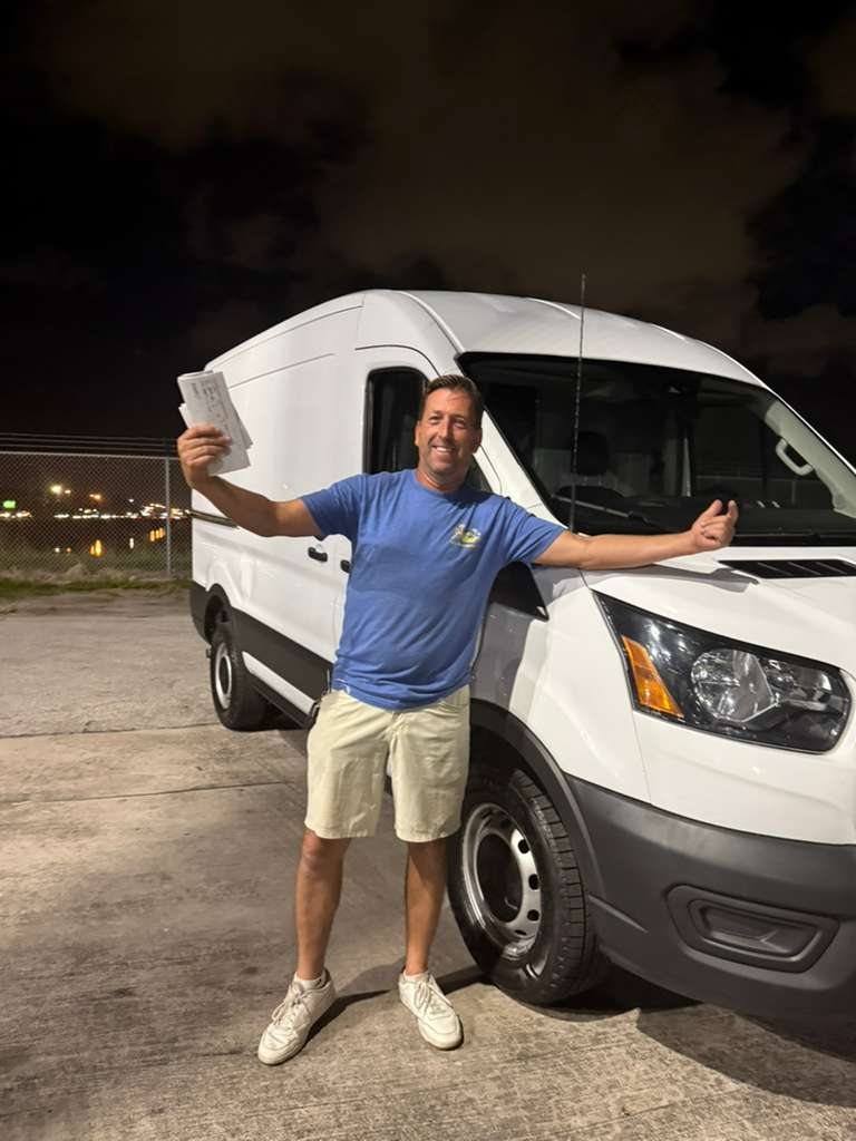 A buyer celebrating beside his white cargo van